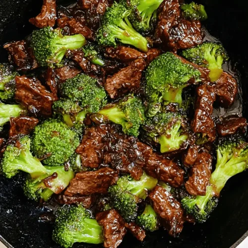 Delicious beef and broccoli recipe stir-fry in a vibrant blue cast iron skillet, ready to serve.