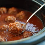 Close-up of delicious meatballs simmering in a rich red sauce, showcasing a mouth-watering crockpot meatball recipe.