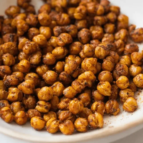 Close-up of a bowl filled with perfectly seasoned, crispy Spicy Roasted Chickpeas.