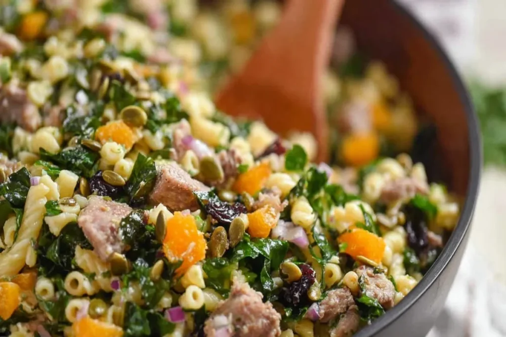 Harvest Pasta Salad with pasta, kale, turkey, cranberries, mandarin oranges, red onion, and pumpkin seeds.
