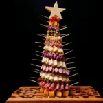 A vibrant Charcuterie Tree made with cheese, cured meats, and olives on a decorative wooden board against a black background.