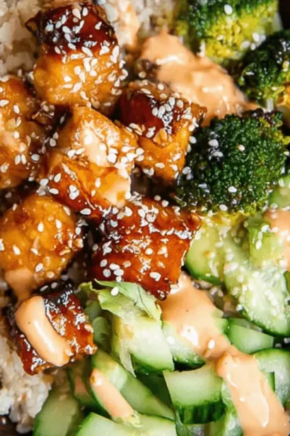 Close-up of a vibrant Crispy Bang Bang Salmon Bites Bowl served in a rustic wooden bowl, featuring glazed salmon, rice, broccoli, avocado, and creamy sauce.