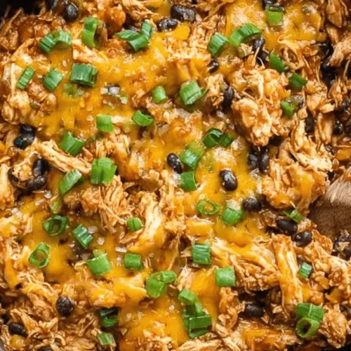 Vibrant Southwest Chicken Skillet with melted cheese, black beans, and fresh scallions, presented in a metallic pan.