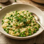 Creamy Spring Pea Risotto in a white bowl garnished with fresh herbs