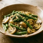 Asparagus and mushroom pasta dish served in a white bowl